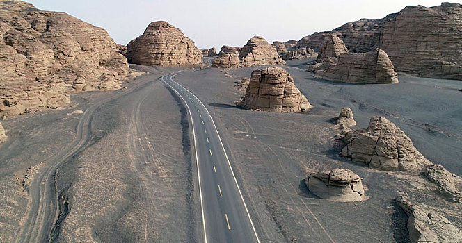 新疆哈密,公路修到荒原戈壁,游客欣赏奇景雅丹