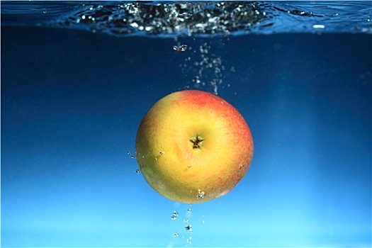 苹果,水,溅,上方,蓝色背景