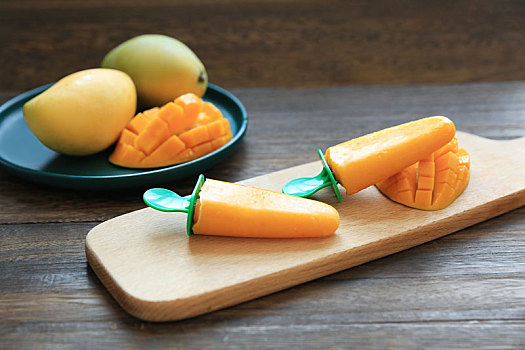 一盘新鲜的芒果被切好放在木板上的盘子里