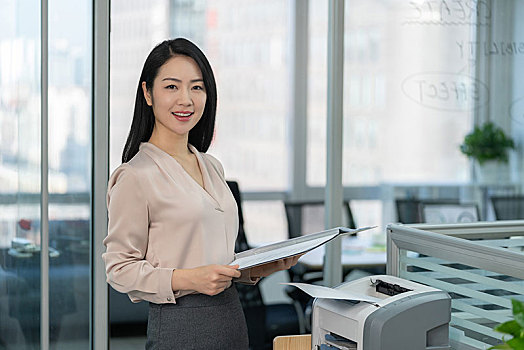 年轻商务女士使用打印机