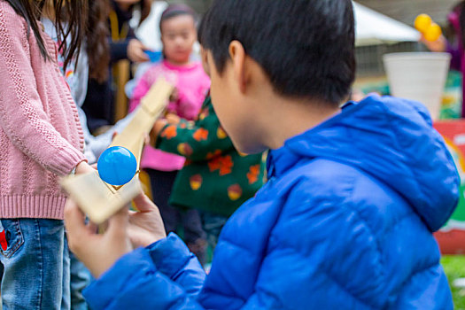 一群小孩在室外公園,玩著传球接龙游戏