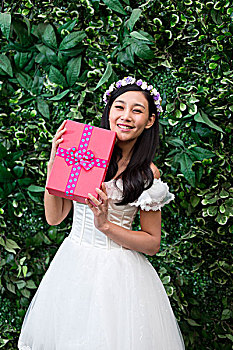 带花环的年轻女人抱着礼物盒