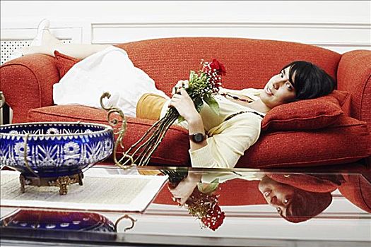 肖像,年轻,女人,躺着,沙发,拿着,花束