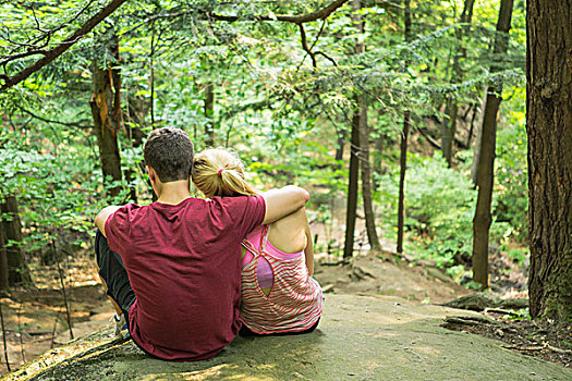 年轻,情侣,坐,石台,树林,搂抱,后视图