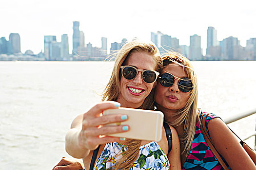 两个女人,智能手机,水岸,天际线,纽约,美国