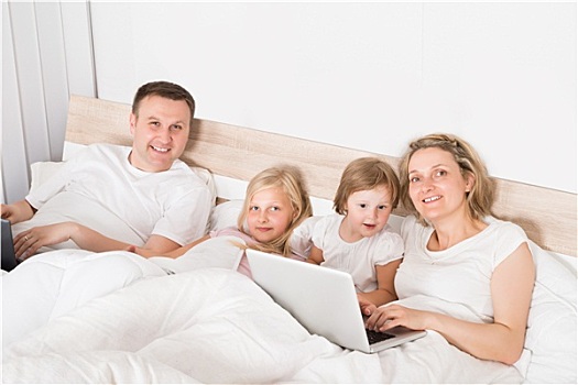 年轻家庭,笔记本电脑,床上