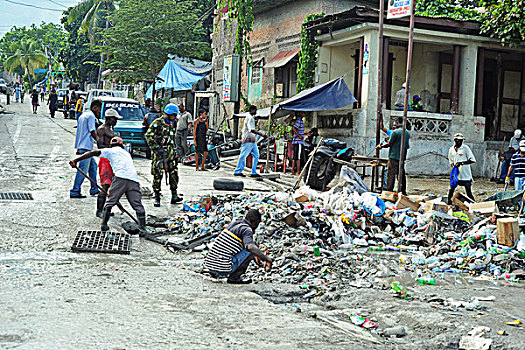 haiti,port,au,prince,people,cleaning,the,plastic,garbage,in,front,of,green,house