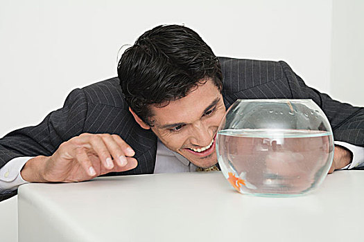 商务人士,看,金鱼,鱼缸,微笑