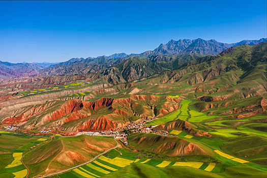 青海省祁连县卓尔山景区丹霞地貌里的油菜花田