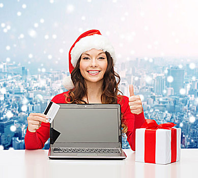 圣诞节,休假,科技,购物,概念,微笑,女人,圣诞老人,帽子,信用卡,礼盒,笔记本电脑,展示,竖大拇指,手势,上方,雪,城市,背景