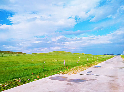 蓝天白云下一条延伸的路穿过草原