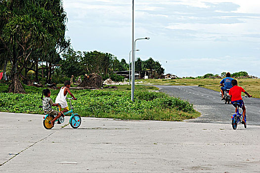 tuvalu,funafuti,portrait,of,a,shirtless,boy,in,red,shorts,laughing,while,sitting,on,steps