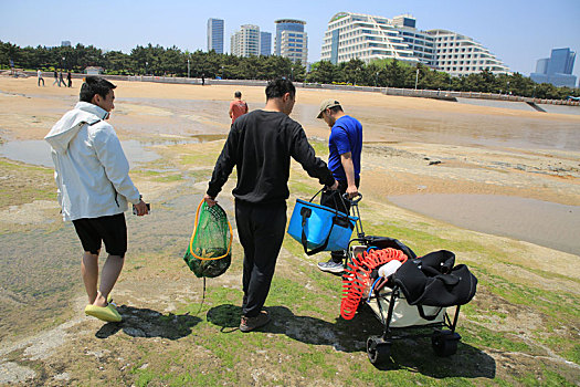 山东省日照市,90后小伙潜水捞海鲜上岸,游客蜂拥而至看稀罕