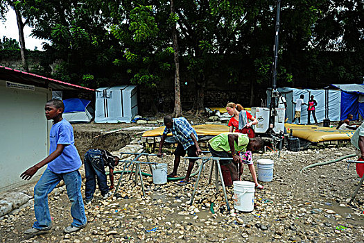 haiti,port,au,prince,petionville,club,camp,local,adults,extracting,water,from,well