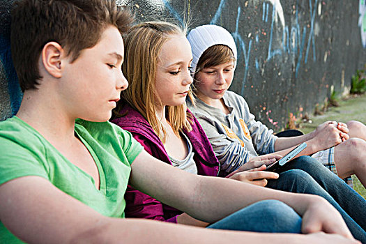 三个,青少年,平板电脑,坐,正面,墙壁,涂鸦
