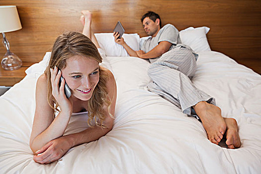 女人,打手机,男人,床上