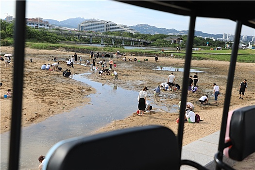 山东省日照市,太公岛游人如织,赶海拾贝做游戏乐在其中