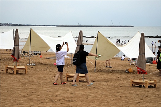 山东省日照市,海边凉爽宜人,游客嬉水踏浪赶海乐享美好周末