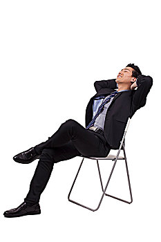 一个坐在白色折叠椅上的青年商务男士