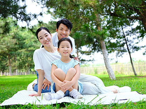 快樂的三口之家在公園玩耍