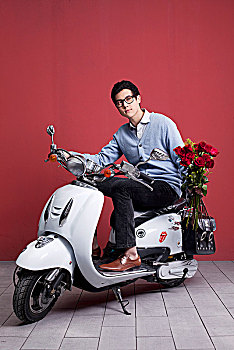 骑摩托车送玫瑰的亚洲男孩
