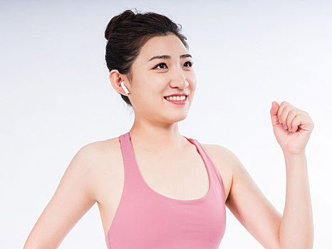 穿運動背心的年輕女性聽音樂熱身