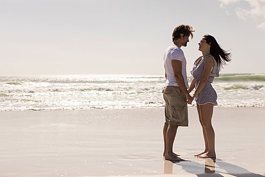 浪漫,年轻,情侣,握手,互相看,海滩