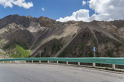 中国新疆夏季蓝天白云下高山草原g217独库公路弯道特写