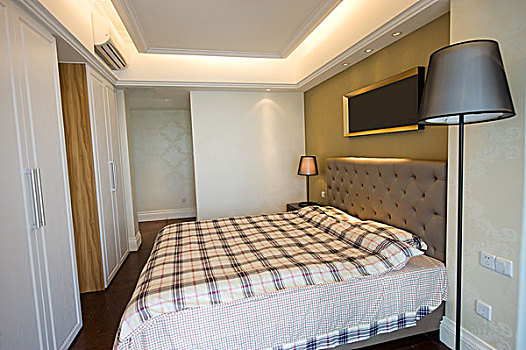 主卧室夫妻躺在床上使用电脑现代,主卧室,室内躺在床上玩电脑的青年