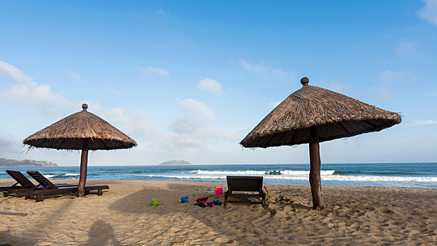 海南万宁香水湾沙滩上的草棚和躺椅