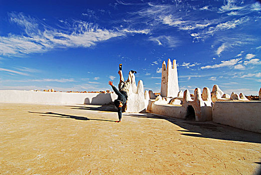 algeria,melika,a,boy,performing,handstand,against,sky,at,the,entrance,of,melika