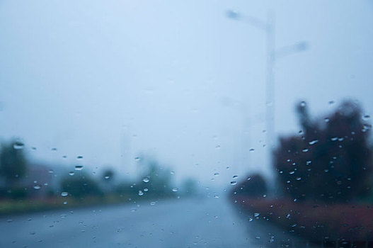 雨天通过车前窗看空旷的城市道路
