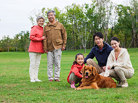 快乐的五口之家和宠物狗在公园玩耍