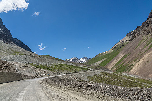 新疆蓝天白云下独库公路高原砂石路汽车背景