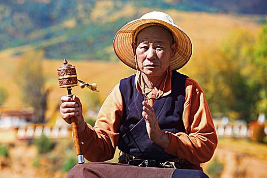 手拿转经筒的西藏老人