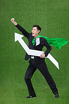 草地创意商务男士披着绿色披风抱着箭头符号