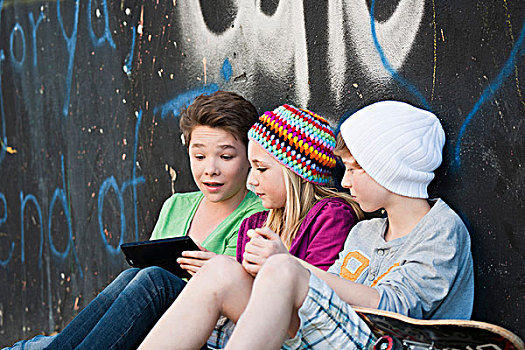 三个,青少年,平板电脑,坐,正面,墙壁,涂鸦