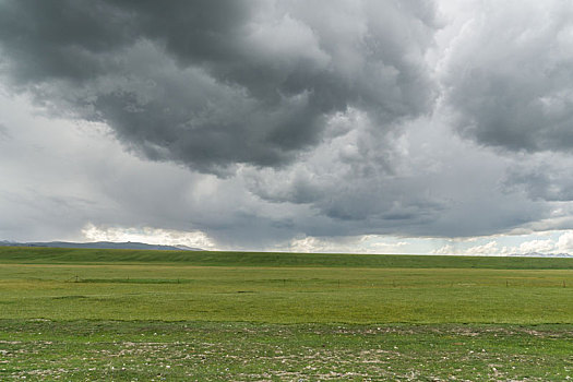 中国新疆夏季蓝天白云下g217独库公路积雨云下的高原草地