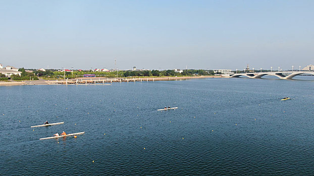 山东省日照市,运动员训练泛舟湖面,蓝天下的水上公园景色优美