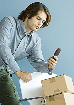 男人,看,手机,靠着,椅子,堆积,纸板箱