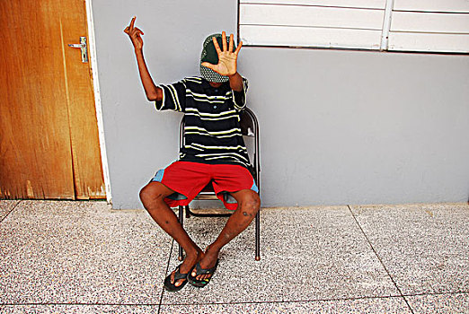 dominica,roseau,juveniles,prison,social,center,teenager,masking,his,face,and,showing,middle,finger
