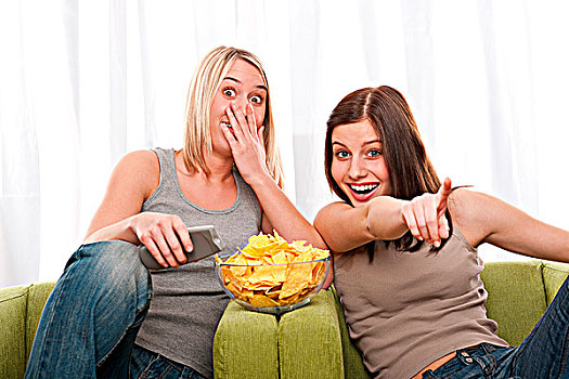 两个,女青年,看电视,吃,薯片