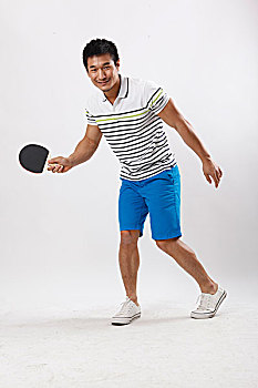 一个穿休闲装打乒乓球的青年男士