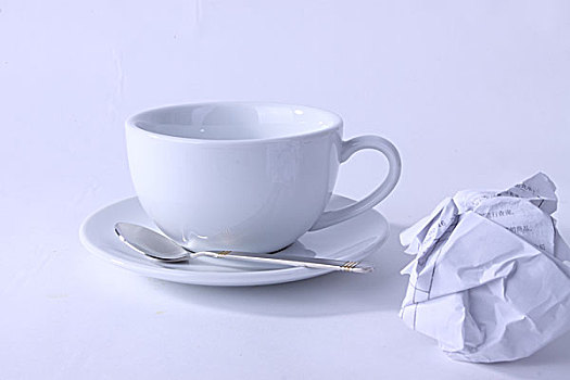 一个空的咖啡杯和一团废纸