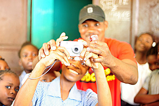 haiti,port,au,prince,teacher,helping,boy,taking,picture