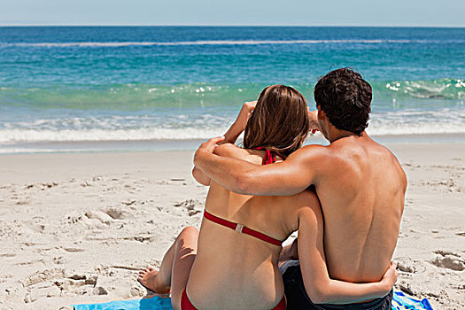 后视图,坐,夫妇,海滩,毛巾,指向