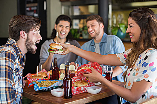 微笑,女人,喂食,汉堡包,男性,朋友,餐馆