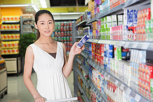 一个青年女人在超市购买饮料