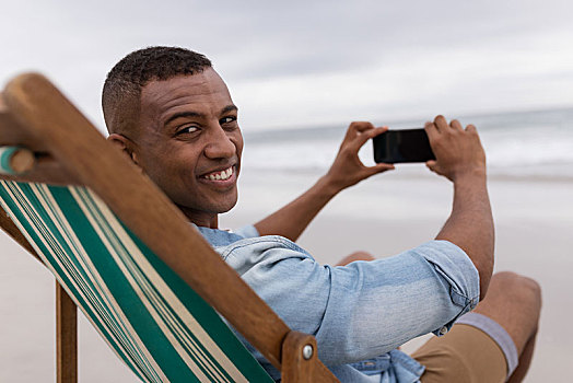 男人,按,手机,坐,沙滩椅,海滩