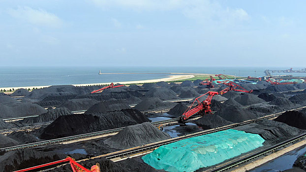山东省日照市,航拍蓝天白云下的煤炭堆场,运输生产繁忙有序
